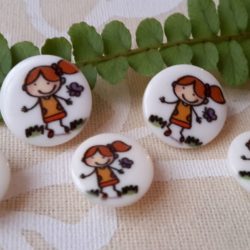 Bouton - La fillette et le papillon sur fond blanc