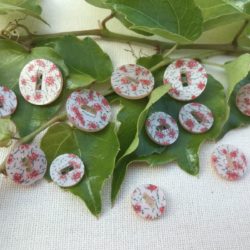 Bouton - Plat et rond, fleurs roses sur rose pâle